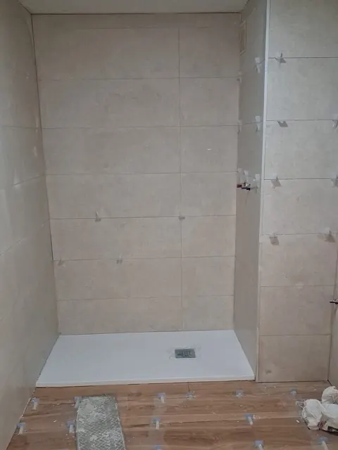 Alicatado de gran formato y plato de ducha extraplano durante la reforma de un baño